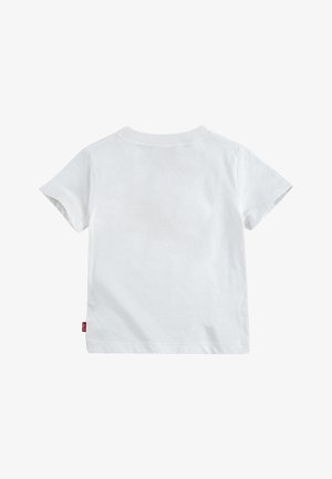 T-shirt en coton blanc à manches courtes et col rond. Présente une petite étiquette de logo rouge sur le côté inférieur. Texture lisse.