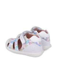 Hvide sandaler til småbørn med et farverigt vanddråbemønster, velcrobånd og udskæringer, der har en struktureret gummisål for godt greb.