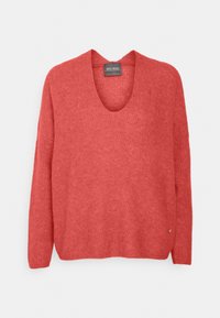 Korallrosa stickad tröja med djup V-ringning, långa ärmar och lös passform. Har en subtil textur och en liten logotypdetalj vid fållen.