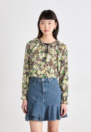 Floral and leopard print long-sleeve top with a gathered neckline, paired with a blue denim skirt featuring a ruffled hem and front patch pocket.