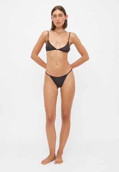 Melnā bikini komplekts ar trīsstūrveida augšdaļu un plānām siksnām, kas apvienots ar minimālas seguma apakšām. Gluda tekstūra, vienkāršs dizains, bez rakstiem.