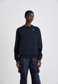 Felpa blu navy realizzata in tessuto morbido, con collo a girocollo, caratterizzata da un design cucito e un piccolo logo sul petto.
