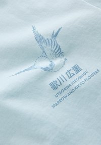 Hellblauer Stoff mit einer detaillierten blauen Spatzenillustration und dem Text „UTAGAWA HIROSHIGE SPARROW AND KIKYO FLOWERS“ auf Englisch und Japanisch.