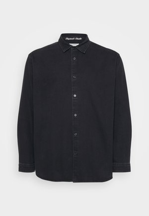 Camisa de botón de manga larga negra con cuello, costuras visibles y etiqueta "Originals Studio" en el interior del cuello.