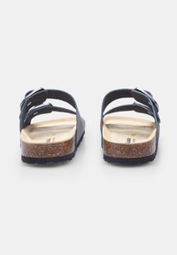 Sandali in pelle nera con due strap regolabili, soletta in sughero, suola testurizzata e finitura opaca naturale sulla soletta interna.