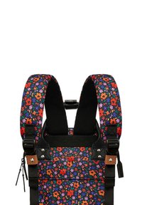 Babytrage mit Blumenmuster, die mehrfarbige Blumen auf schwarzem Hintergrund zeigt, gepolsterte Schultergurte und verstellbare Schnallen hat.