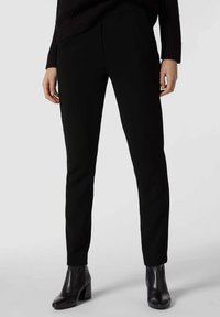 Pantaloni neri a gamba affusolata realizzati in un tessuto liscio e elastico. Presentano tasche laterali, una vita piatta e una vestibilità aderente lungo le gambe.