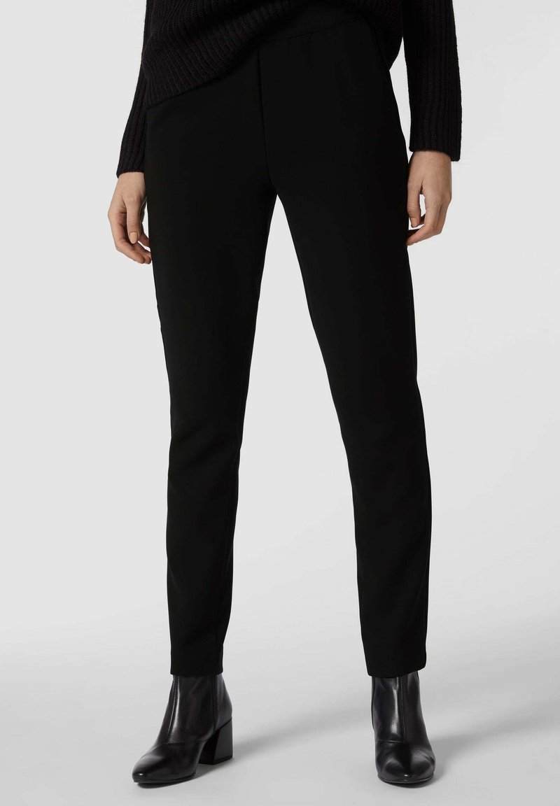 Pantaloni neri a gamba affusolata realizzati in un tessuto liscio e elastico. Presentano tasche laterali, una vita piatta e una vestibilità aderente lungo le gambe.
