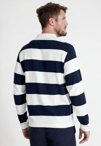 Polo a maniche lunghe a righe blu navy e bianche in tessuto di cotone, con colletto, polsini a costine e orlo dritto con spacchi laterali.
