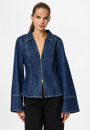 Denimjakke med lynlås foran, store revers og flagrende ærmer. Mørkeblåt stof med kontrastfyldte gule sømme.