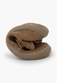 Zapato de ante marrón con un diseño suave y plegado. Presenta detalles cosidos y una suela de goma con un patrón texturizado para un mejor agarre.