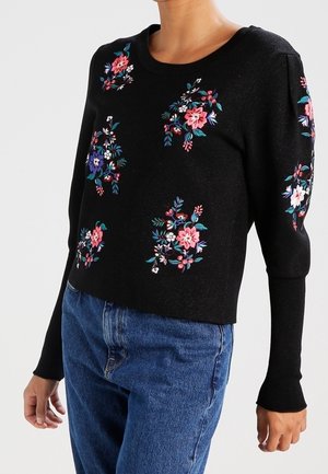 Maglione nero con ricami floreali colorati, scollo rotondo e maniche lunghe. Design cropped con polsini e orlo a coste.