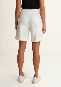 Shorts bianchi in felpa con orlo piegato, realizzati in materiale morbido, con logo "FREDDY" ricamato sul retro. Design casual.
