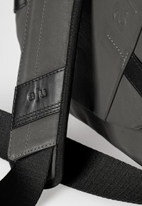Grau gefärbte Stoff-Schultertasche mit einem strukturierten Ledertragegurt und schwarzen Akzenten. Verfügt über ein Logo-Label und verstärkte Nähte.