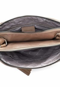 Vista dall'alto di una borsa a tracolla beige aperta che mostra due scomparti principali con cerniere e un rivestimento interno grigio a fantasia.