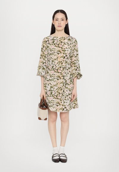 Floral dress in light beige with pink and green patterns, loose sleeves, belted waist, paired with white socks and dark brown shoes.