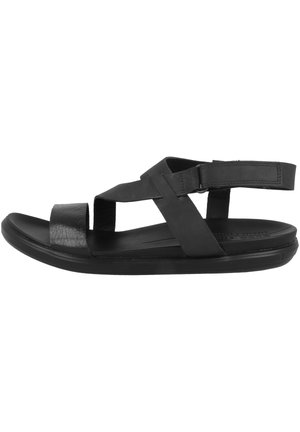 Sort sandal med åben tå, to brede krydsede remme og en bagrem med velcro, flad sål.