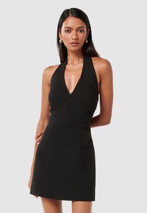 Musta halterneck-mekko syvällä V-pääntiellä, istuvalla bodysuitilla ja levenevällä hameella. Sujuva, matta kangas, jossa piilotettu etuvetoketju.