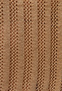 Tejido de punto marrón claro con franjas verticales alternas sólidas y caladas que crean un patrón texturizado.