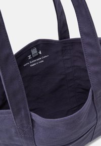 Ciemnogranatowa torba bawełniana na ramię z mocnymi uchwytami, z przestronnym wnętrzem i metką z napisem "100% Bawełna Zrównoważona, Wyprodukowano w Indiach."