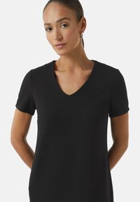 Black short-sleeve dress with a V-neck, featuring a textured fabric and a straight cut, providing a simple and modern silhouette.