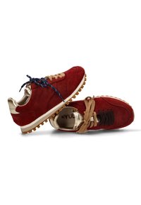 Un par de zapatillas de ante rojas con acentos dorados, suelas de goma y cordones desiguales en azul marino, marrón y negro, mostradas desde vistas superiores y laterales.