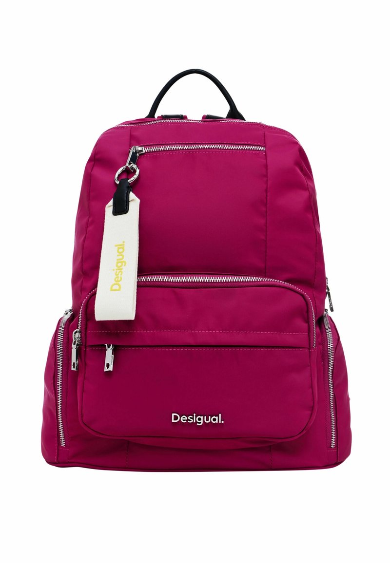 Sac à dos magenta avec plusieurs compartiments zippés, poignée noire et étiquette en tissu blanc portant la mention « Desigual » attachée près de la fermeture éclair supérieure.