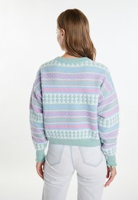 Pulover v pastelnih odtenkih, pleten z geometrijskim vzorcem, z okroglim izrezom in rebrastimi manšetami, izdelan iz mehkega, teksturiranega materiala.