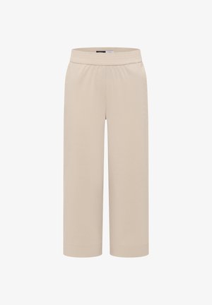 Beżowe spodnie o szerokich nogawkach z elastycznym pasem i mankietami u dołu, prezentowane na jednolitym białym tle.