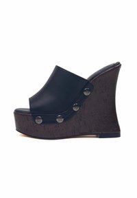 Sandali con zeppa nera, con una tomaia liscia e una base texture in sughero. Presentano accenti in metallo argentato e un design con la punta aperta.