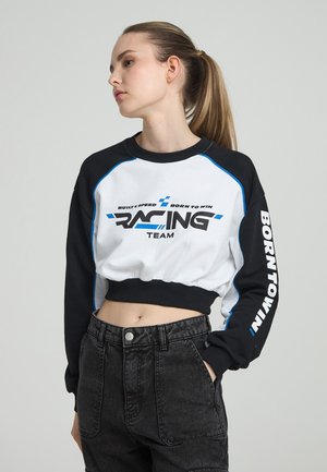 Przycięta bluza w czarno-białej bawełnie z niebieskimi akcentami. Z przodu umieszczony nadruk "RACING TEAM", a rękawy ozdobione napisem "BORNTOWN".