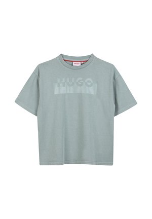 Camiseta de algodón verde claro con mangas cortas, cuello redondo y un logotipo tonal "HUGO" impreso en el pecho. Textura suave, corte relajado.