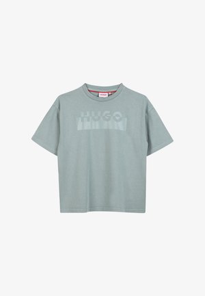 Camiseta de algodón verde claro con mangas cortas, cuello redondo y un logotipo tonal "HUGO" impreso en el pecho. Textura suave, corte relajado.