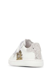 Sneakers bianchi con un retro scintillante argentato, dettagli decorativi dorati e cinturini in velcro. Esterno in pelle liscia e suola testurizzata.