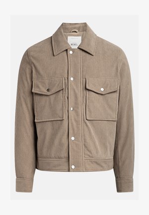 Corduroy jacket in tan with a button-up front, two chest pockets, and ribbed texture. Features metal snap buttons and a collared neckline.
