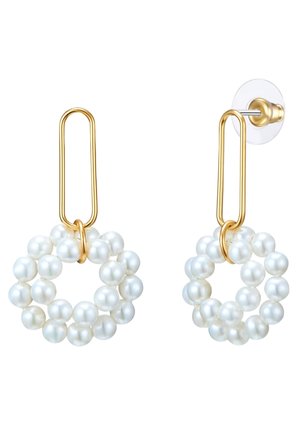 Des boucles d'oreilles en métal doré présentant un grand design en forme de trombone, ornées d'un groupe circulaire de perles de culture blanches créant un aspect texturé.