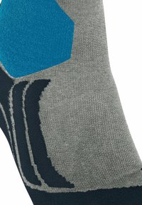 Grijze sok met een gestructureerd patroon, voorzien van een blauw hexagonaal ontwerp en donkere accenten. Geribbelde bovenkant voor een goede pasvorm en duurzaamheid.