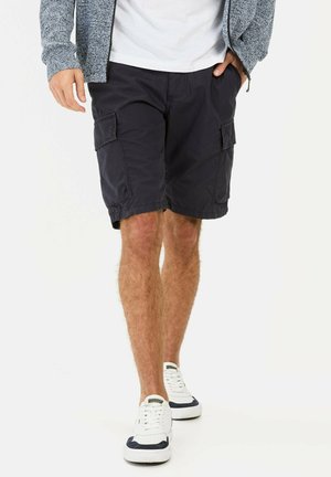 Navy cargo shorts made of lightweight fabric, featuring side pockets and a relaxed fit. Paired with white sneakers with navy accents.