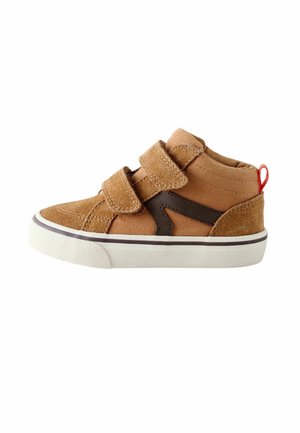 Baskets marron pour tout-petit avec deux bandes velcro, semelle blanche, détail noir sur le côté et languette rouge au talon sur fond blanc.
