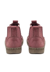 Botines de ante rosa con un acabado texturizado, paneles laterales elásticos y una suela beige resistente. Incluye lengüetas para facilitar su calzado.