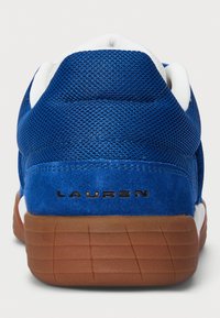 Baskets en mesh bleu et en suède avec des accents blancs et une semelle en caoutchouc marron. Présente un petit logo sur le talon et une surface texturée.