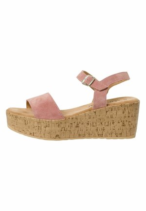 Les sandales à talon compensé présentent des brides en daim rose, un design ouvert à l'avant, une boucle réglable à la cheville et une base en liège texturé.