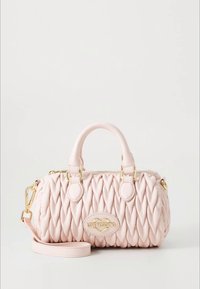 Rausvos spalvos siuvinėta rankinė su struktūruota forma, auksinės spalvos metalo detalėmis ir nuimama petneša. Priekyje yra logotipo plokštelė.