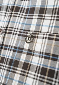 Kariertes Hemd in Braun-, Blau- und Beigetönen, aus Stoff mit einer strukturierten Webart. Enthält eine dekorative "b"-Stickerei auf der Brust.