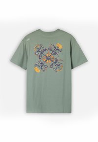 T-shirt en coton vert à manches courtes, avec un motif floral en orange et bleu dans le dos, et un petit logo sur l'épaule.