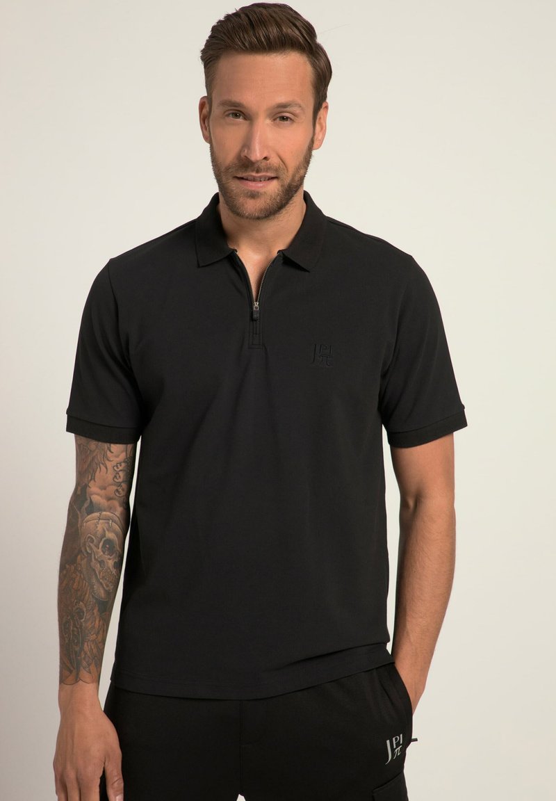 Polo shirt negro con cremallera, hecho de un tejido suave, con mangas cortas y un logo sutil en relieve en el pecho. Diseño oscuro y minimalista.