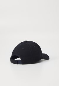 Svart baseball caps med en buet skjerm, laget av stoff, med sydd sømmer og en justerbar stropp bak.