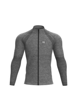 Haut de sport gris à manches longues avec fermeture éclair, rayures texturées sur les manches et les épaules, et un petit logo sur le côté gauche de la poitrine.