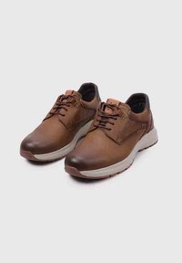 Zapatos de cuero marrón con un acabado suave, diseño con cordones y suela blanca acolchada. Presenta acentos curvados y detalles cosidos.