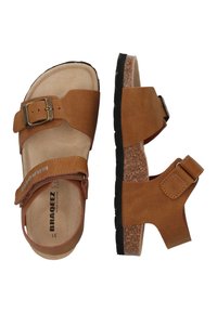 Braune Kunstleder-Sandalen mit einem Korkfußbett, verstellbaren Riemen, einer Metallschnalle und einer strukturierten schwarzen Gummisohle.